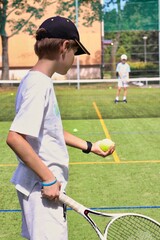 Two boys playing tennis on the local tennis court © Gosia