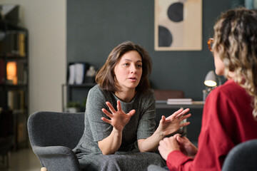 Engaged in deeply meaningful discussion during a therapy session in a cozy and comfortable office setting involving intense hand gestures emphasizing important points