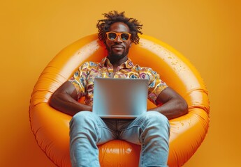 Man on inflatable chair, working on laptop