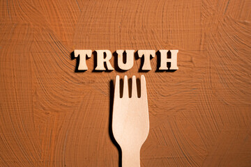 however, the fork is wooden, the background is brown