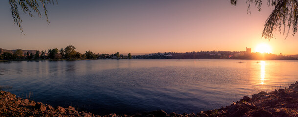Panoramic view of Saint Roque Lake in Villa Carlos Paz at sunset while people enjoy rowing