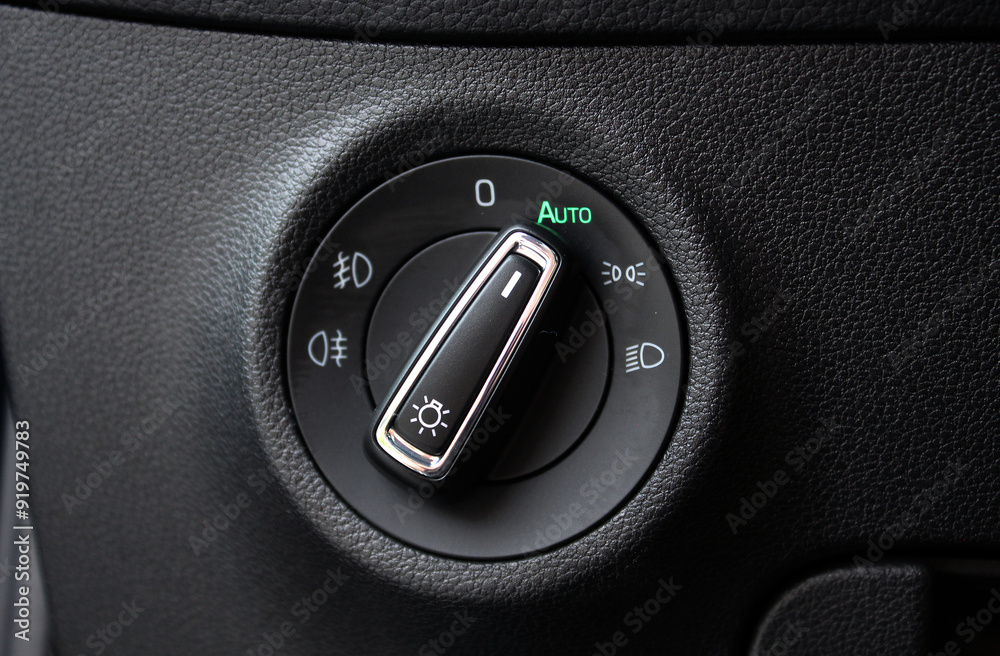 Wall mural close up of light control in car. dashboard of the car's interior is black with a dipped headlamp sw