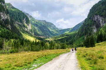 Two hikers tourists are walking in mountains
