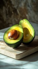 Halved avocado on a wooden board with natural lighting in a rustic kitchen