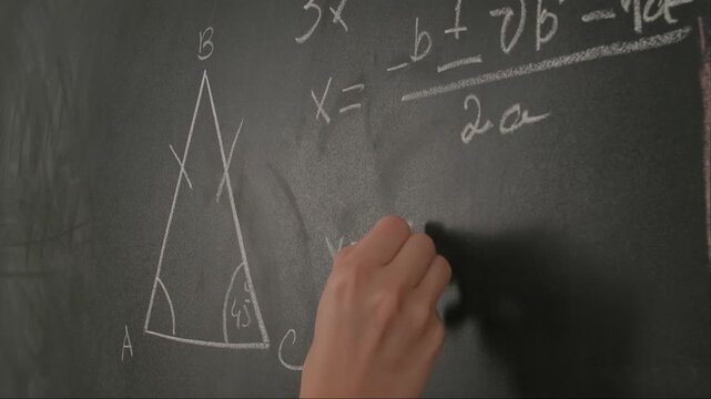 Close up of woman hand writing text and trigonometry formulas on chalkboard, professor writes on blackboard or student solving task. Education and science concept.