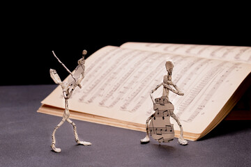 the figures of the violinist and cellist are made of music paper