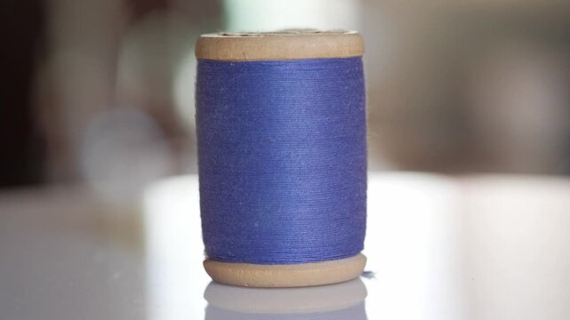 Spool of blue cotton thread for sewing close-up