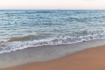 Soft ocean wave on clean sandy beach background.