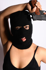 body positive latina woman thief with balaclava posing sexy with gun