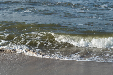 Surf on the Baltic Sea coast. Wave on a sandy beach.