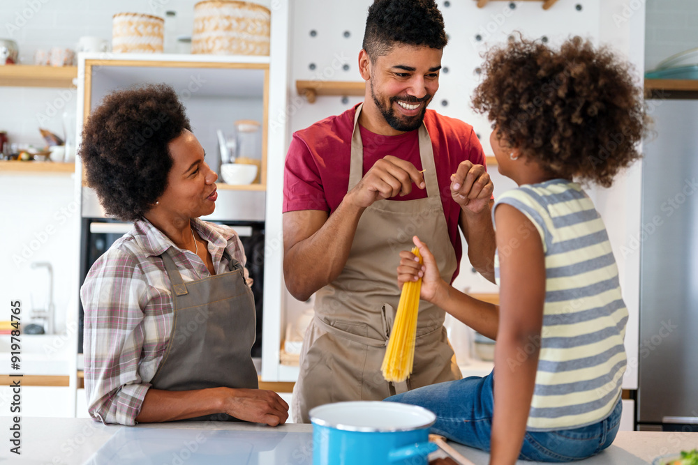 Wall mural happy african american family preparing healthy food in kitchen, having fun together on weekend