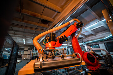 A robotic arm in a woodworking factory, equipped with suction technology, lifts and processes...