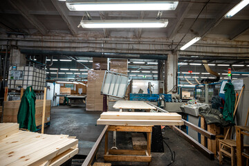 modern woodworking factory interior showing stacks of wooden boards and workers in the background,...