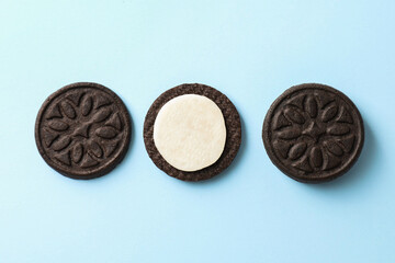 Tasty sandwich cookies with cream on light blue background, top view