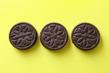 Tasty sandwich cookies on green background, top view