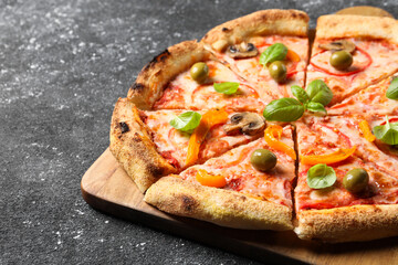 Cut delicious vegetarian pizza on grey table