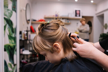 Fototapeta premium They cut the girl's hair. Bangs are cut 