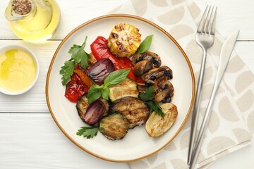 Delicious grilled vegetables with spices served on white wooden table, flat lay