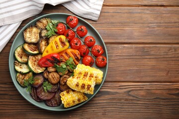 Delicious grilled vegetables on wooden table, top view. Space for text
