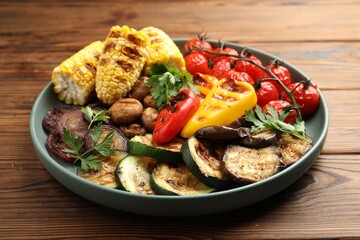Delicious grilled vegetables on wooden table, closeup