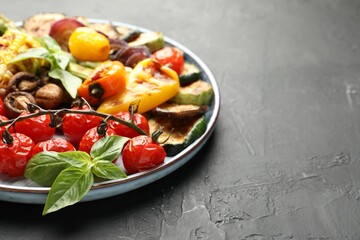 Delicious grilled vegetables on grey textured table, closeup. Space for text