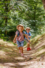 Young scout explorers hiking through a lush forest, having fun