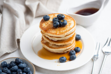 Blueberry buttermilk pancakes stack on white background. Sweet breakfast meal