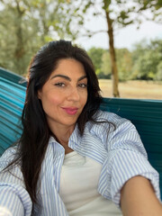 Beautiful woman relaxing in hammock in the summer park 