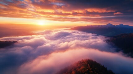 Naklejka premium Majestic Sunrise Above the Clouds in Mountain Range - Breathtaking aerial view of a sunrise casting vibrant hues over a sea of clouds and distant mountain peaks. Perfect for nature lovers.