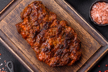 Fresh juicy delicious beef steak on a dark background