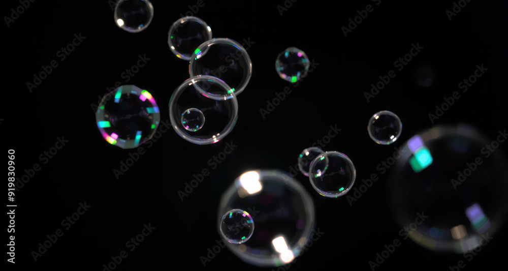 Wall mural soap bubbles of various sizes floating against a black background, creating a stark contrast. the br