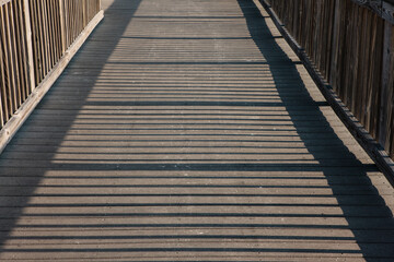 The morning sun casts long shadows across the protective boardwalk leading to the gulf beaches within Topsail Hill Preserve State Park, Santa Rosa Beach, Florida in mid-April
