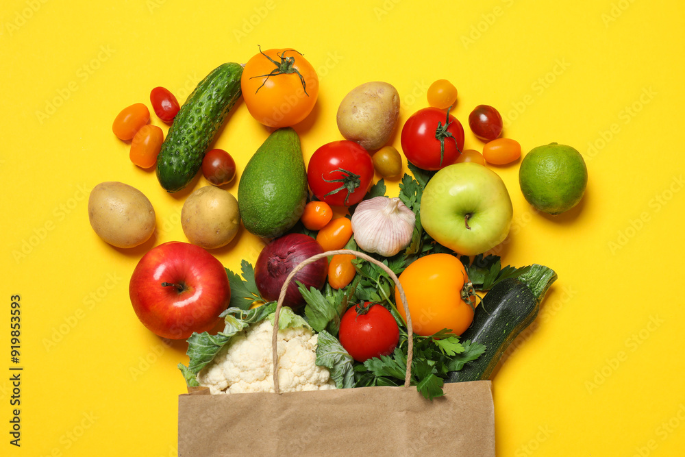 Sticker Delivery of vegetarian products. Paper bag with different vegetables and fruits on yellow background, top view