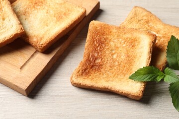 Slices of delicious toasted bread on wooden table, closeup