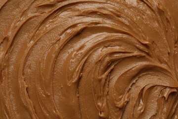 Tasty peanut butter as background, top view