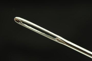 Sewing needle on black background, closeup view