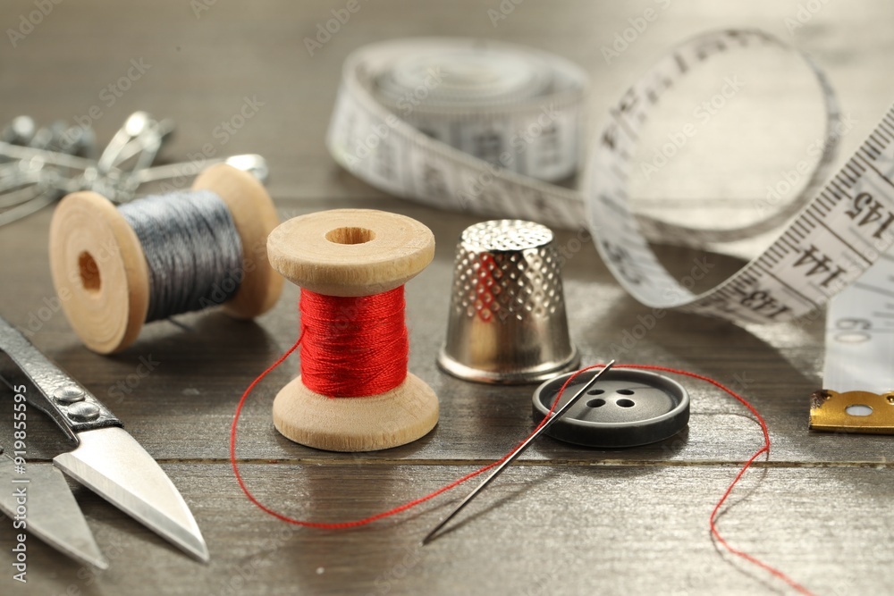 Wall mural Different sewing tools on wooden table, closeup