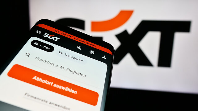 Stuttgart, Germany - 08-06-2024: Mobile phone with webpage of German car rental company Sixt SE in front of business logo. Focus on top-left of phone display.