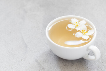 Tea with jasmine in a cup. Light gray background. Copy space	