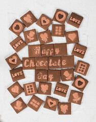 Modern chocolate cookies with chocolate milk filling in the shape of a Happy Chocolate Day, love, heart, rose. White background. Top view