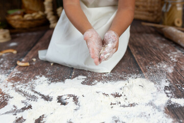 child's hand in flour. little chef playing with food