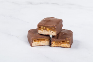 Candy bar with nougat, caramel, peanuts and hazelnuts. In  chocolate. Close up