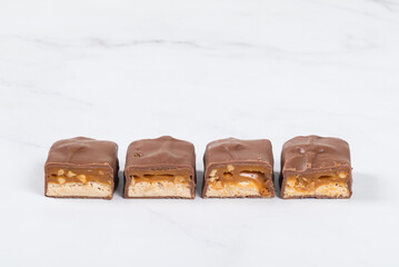 Fitness Candy bar with nougat, caramel, peanuts and hazelnuts. In milk chocolate. Copy space