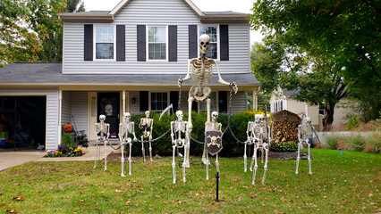 Halloween decorations on the lawn in front of the house. Skeletons and ghosts create an atmosphere of horror and fear.