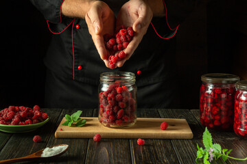 The cook prepares jam with Rubus idaeus. The concept of making sweet raspberry jam on the kitchen...
