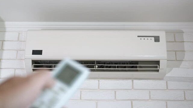 Man hand switch off the air cooling system. A man hand switch the air conditioner to change the temperature in his apartment.