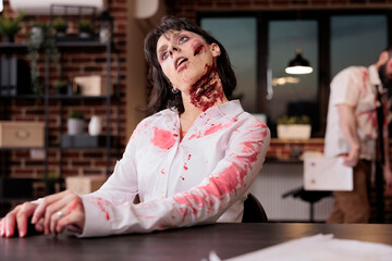 Woman dead on office desk chair after being worked to death, suffering from overwork and lack of sleep. Lifeless worker looking like undead zombie, victim of corporate rat race hustle culture