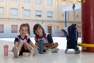 Fototapeta premium Smiling little children sitting on the floor at school