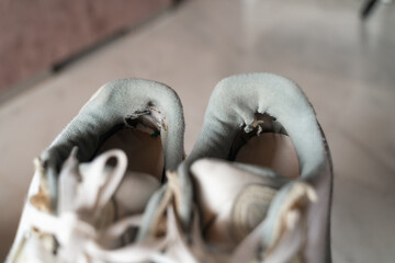 Close-up of well-used sneakers, highlighting the wear and tear, representing the underconsumption core trend focused on sustainability and mindful consumption