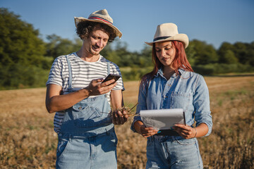 woman and man farmers in the field check quality of the soil